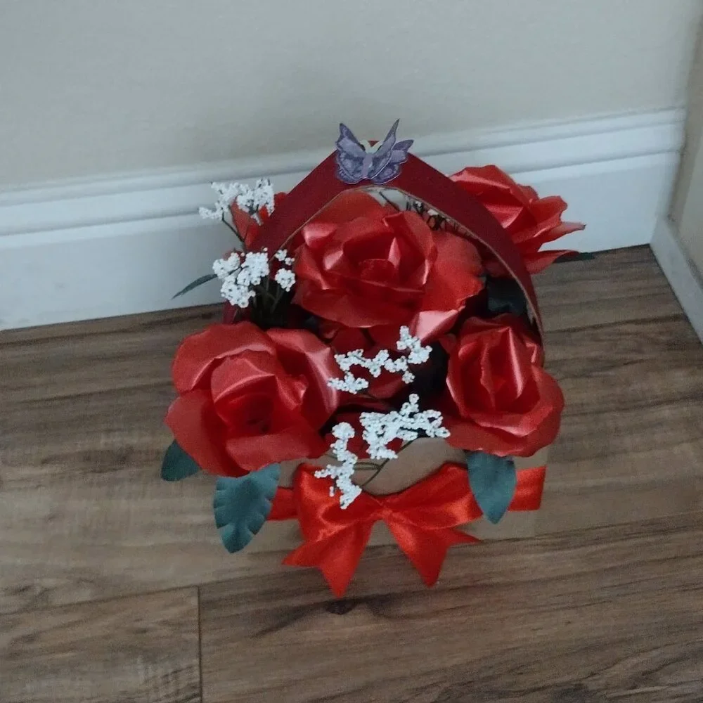 Handmade floral arrangement with plastic ribbon roses.